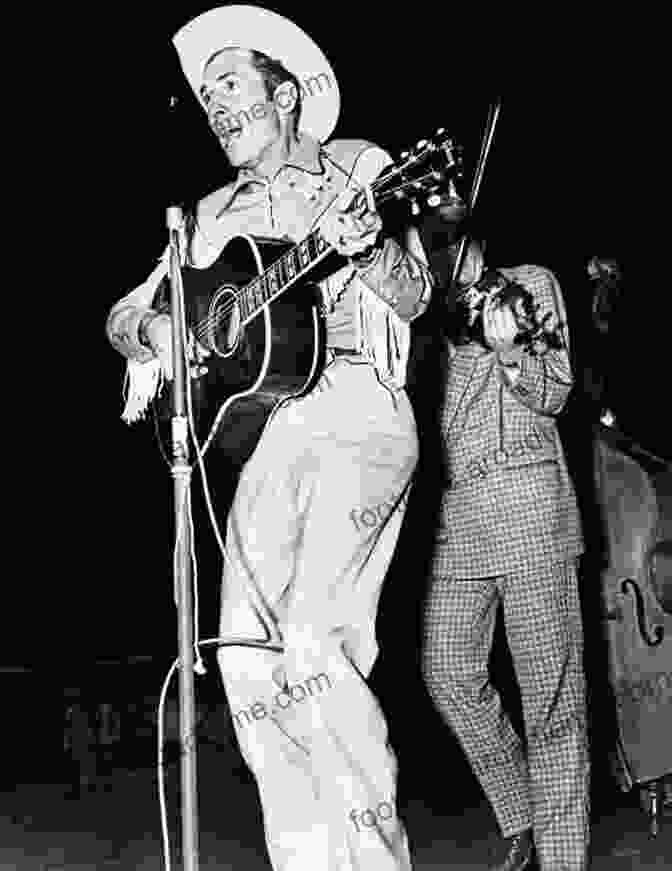 Hank Williams Performing On Stage, Wearing A Cowboy Hat And A Suit, Playing A Guitar And Singing Into A Microphone Hank Williams: The Biography Colin Escott